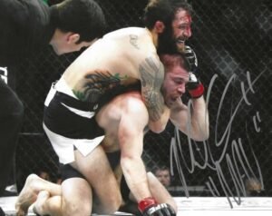 Two MMA fighters in a grappling match, one with blood on his face